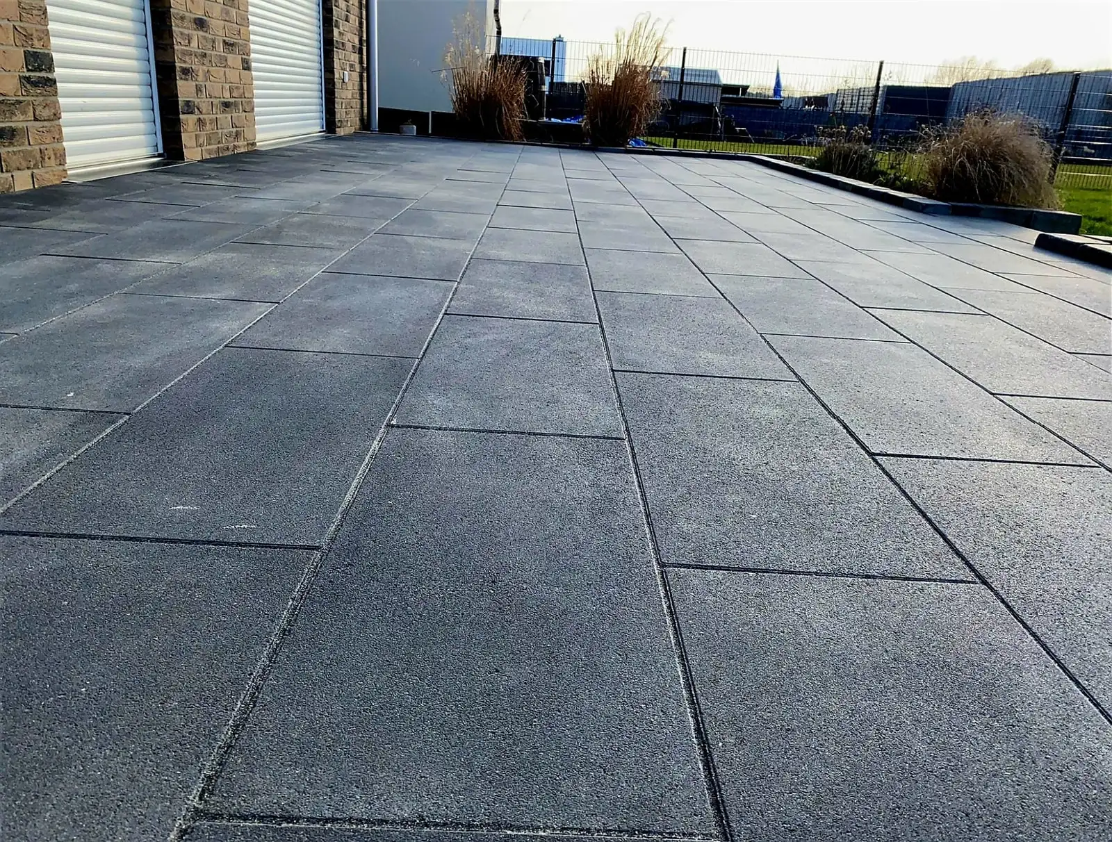 Terrassenfläche mit großformatigen anthrazitfarbenen Platten, gleichmäßig gereinigt.