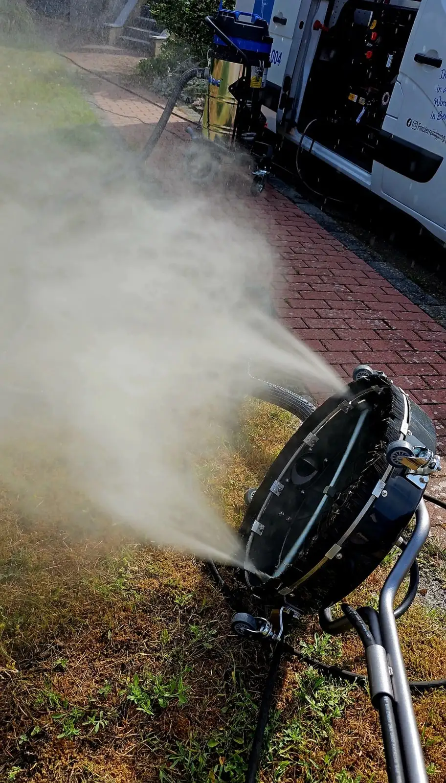 Flächenreiniger von der Seite, das austretende Wasser bildet einen breiten Sprühkegel.